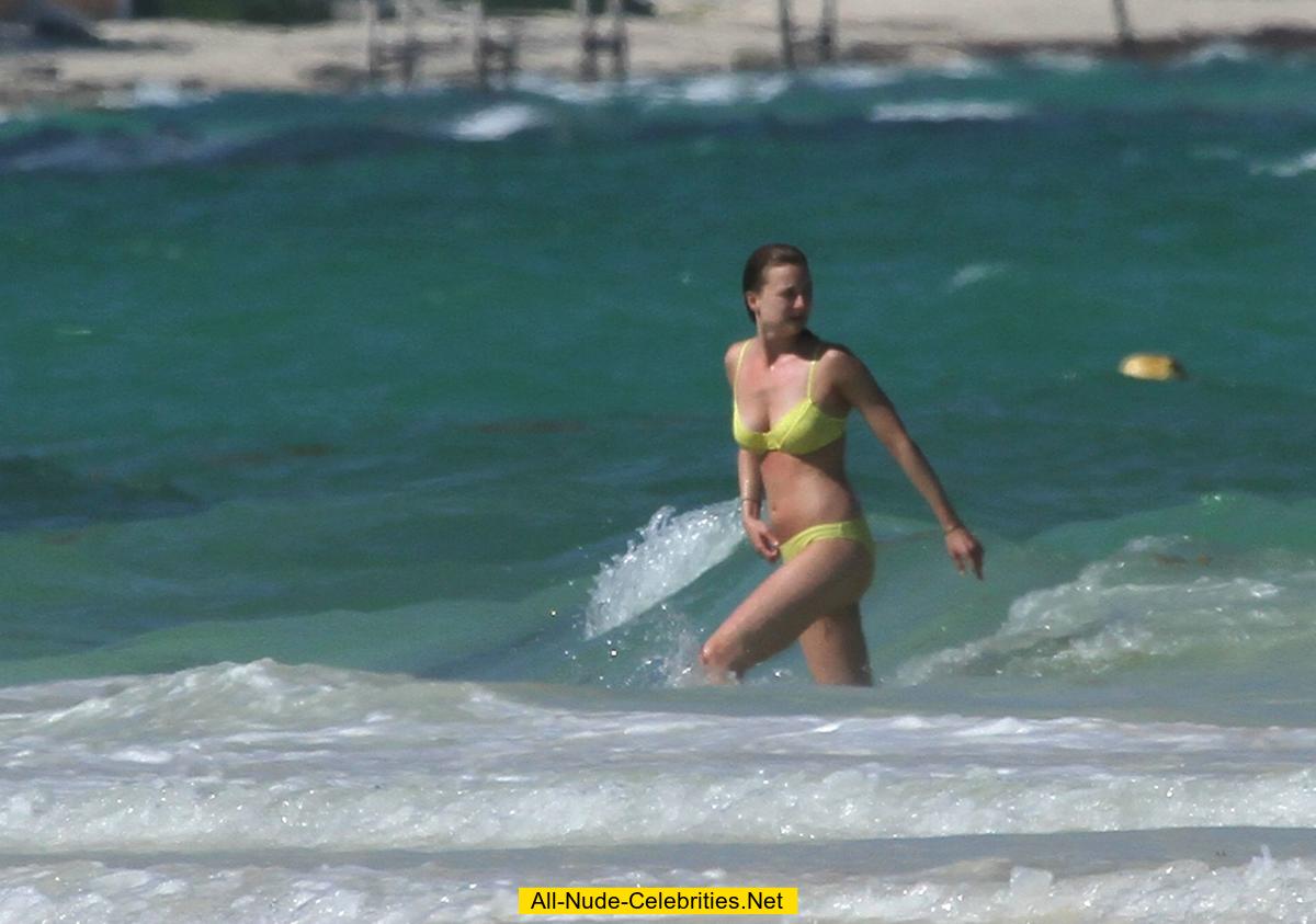 Emily VanCamp in yellow bikini on a beach